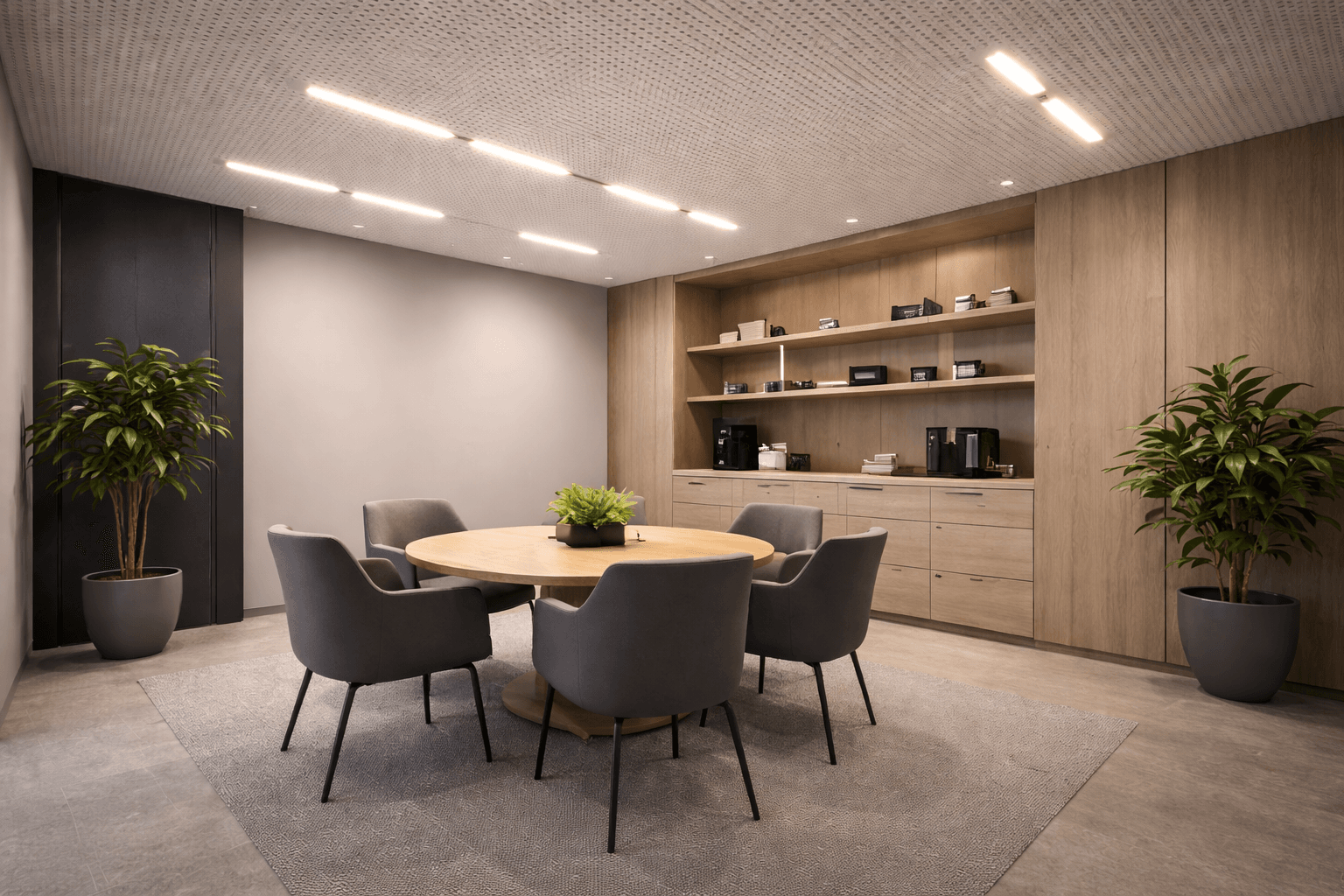 Modern conference room with a round wooden table, five gray chairs, two potted plants, light gray rug, built-in shelves and cabinets. Machine Learning Acoustic Prediction for Stretch Ceilings enhances the clean and minimalist atmosphere.